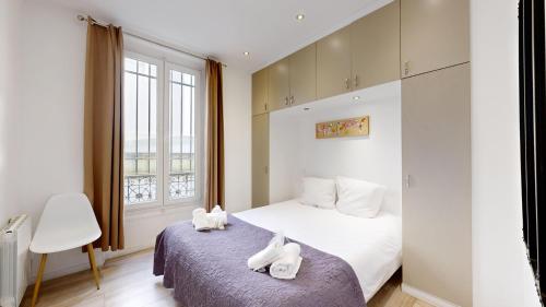 une chambre avec un lit avec des serviettes blanches dessus dans l'établissement Bluestay 1 - Appartement au Cœur de Paris, à Paris