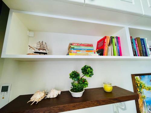 a shelf with books and plants on top of a table at Positano in Varna City