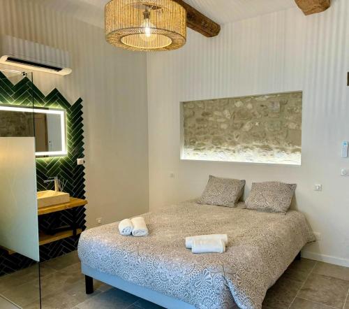 une chambre avec un lit avec deux serviettes dessus dans l'établissement Mas Les Fabrys au coeur du Luberon, à Bonnieux