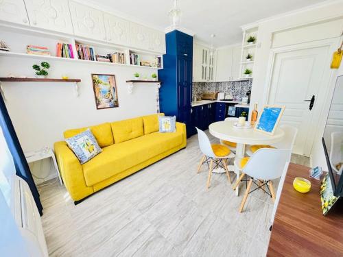 a living room with a yellow couch and a table at Positano in Varna City