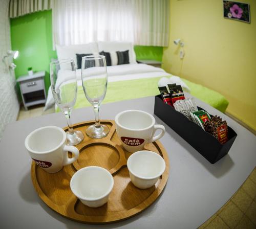 a table with two glasses and a tray with cups and coffeeisers at Breezot Yam in Nahariyya