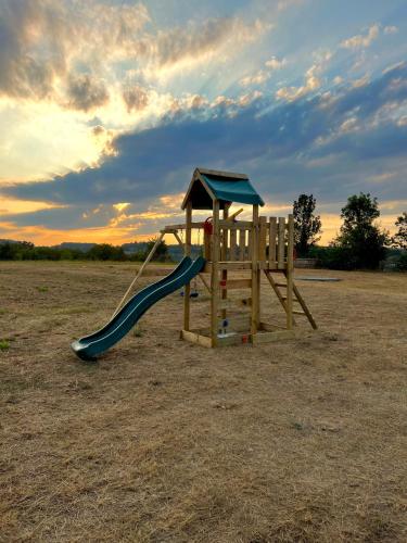 a playground with a slide in a field at Chiaraluce Country House in Massignano