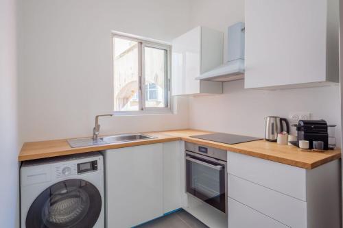 une cuisine avec une machine à laver et un évier dans l'établissement Minimalistic apartment near Vieux-Port by Weekome, à Marseille