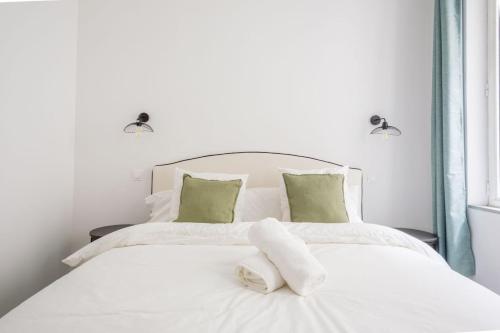 - un lit blanc avec des draps blancs et des oreillers verts dans l'établissement Minimalistic apartment near Vieux-Port by Weekome, à Marseille