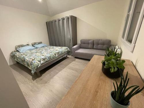 un salon avec un lit et un canapé dans l'établissement Petite maison sympathique, à Saint-Malo