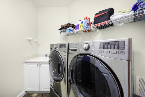 a washing machine in a laundry room with a shelf at Peaceful condo with pool and steps to South Beach in Marco Island