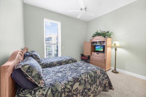 a bedroom with a bed and a dresser and a tv at Peaceful condo with pool and steps to South Beach in Marco Island