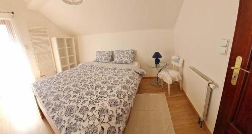 a bedroom with a bed with a blue and white comforter at Lucie in Svitava
