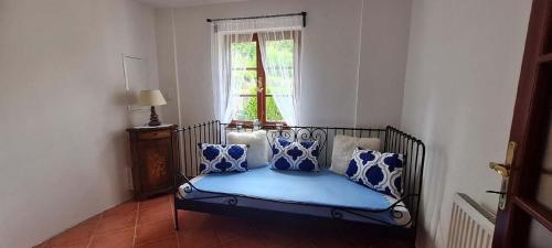 a couch with blue pillows in a room with a window at Lucie in Svitava