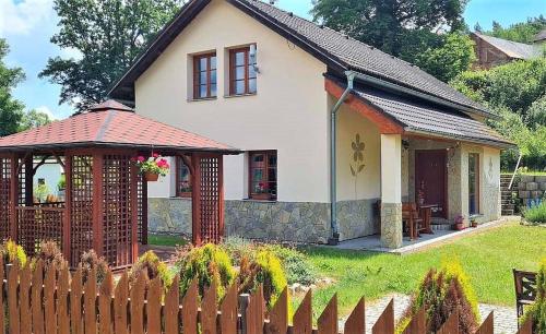 a small white house with a fence in the yard at Lucie in Svitava