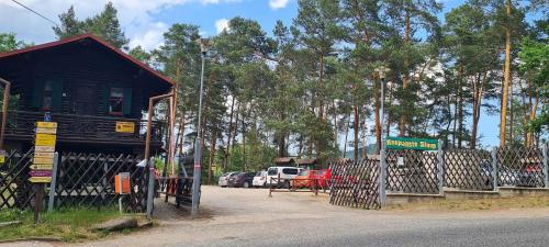 a building with a gate and a parking lot with cars at Lucie in Svitava