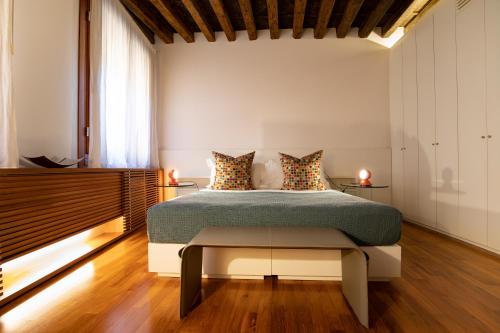 a bedroom with a bed and a bench in it at Ca' della Scimmia - Rialto Bridge, Venice in Venice