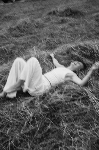 a young child laying on the ground in the grass at Luxury Chalets Gradenbach near Schladming in Haus im Ennstal
