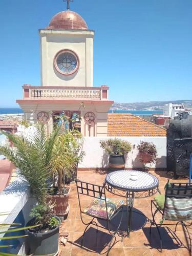 a clock tower on a building with a table and chairs at Tangier Medina Roof Top Apartment with Ocean Views in Tangier
