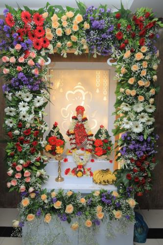 une composition florale et une statue à une fenêtre dans l'établissement Hotel rajlaxmi executive, à Aurangabad
