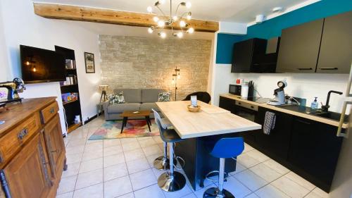 una cucina e un soggiorno con un tavolo e un divano di Gîte Chez Nanou & Ju, Ste Croix Volvestre a Sainte-Croix-de-Volvestre