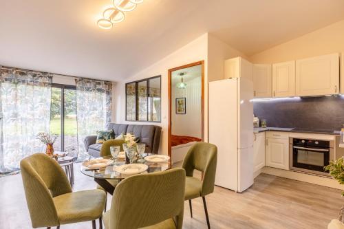 una cucina e un soggiorno con tavolo e sedie di La Couture - Campagne Normande - Proximité Pont-Audemer a Saint-Mards-de-Blacarville