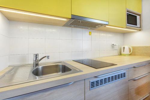 a kitchen with a sink and a microwave at Rooms & Apartments Jana in Cerklje na Gorenjskem