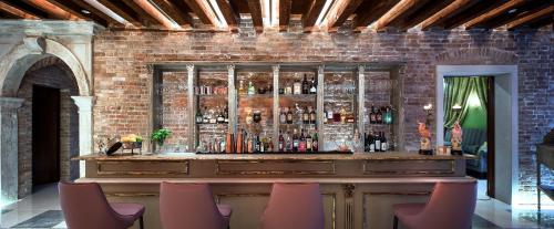 a bar in a brick wall with chairs around it at Hotel Heureka in Venice