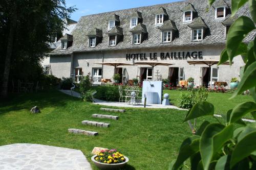 a building with a bowl of flowers in front of it at Le Bailliage Hôtel & Spa in Salers