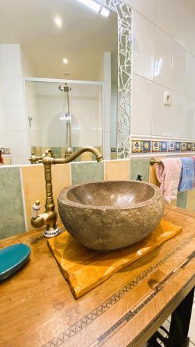 La salle de bains est pourvue d'un grand lavabo en pierre sur un comptoir en bois. dans l'établissement Gîte Chez Nanou & Ju, Ste Croix Volvestre, à Sainte-Croix-de-Volvestre