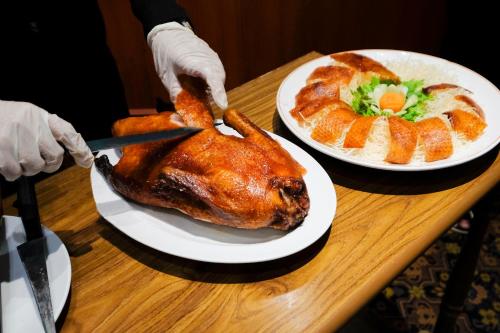 a person cutting a turkey on a table at Royal Phuket City Hotel in Phuket Town