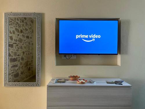 a flat screen tv hanging on a wall at Casa Nina - 10' dalla spiaggia in Gonnesa
