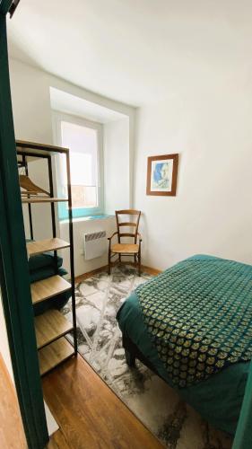 une chambre avec un lit et une chaise dedans dans l'établissement Gîte Chez Nanou & Ju, Ste Croix Volvestre, à Sainte-Croix-de-Volvestre