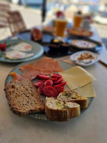 a plate of food with bread and tomatoes on a table at Nyx Chic Manor in Chania Town