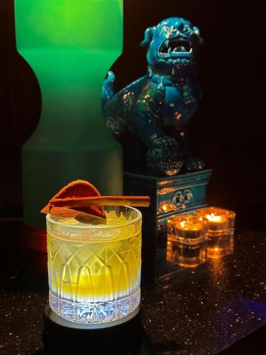 a drink with an orange peel in a glass with lights at Royal Phuket City Hotel in Phuket Town