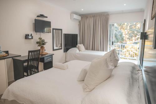 a hotel room with two beds and a window at Beside Still Waters Boutique Hotel in Durban