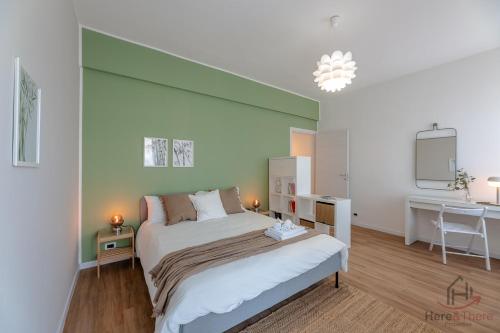 a bedroom with a bed with a green wall at Penthouse panoramic view - Sea 3min - AC - WiFi in Albisola Superiore