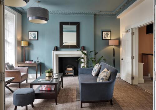 a living room with a couch and a fireplace at Montagu Place Hotel in London