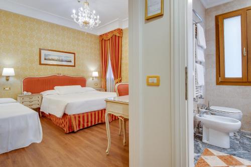 a hotel room with two beds and a bathroom at Hotel Antiche Figure in Venice