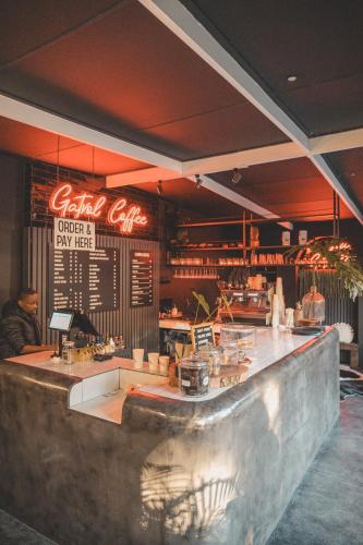 a bar in a restaurant with a man sitting at the counter at Beside Still Waters Boutique Hotel in Durban