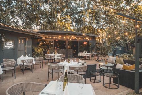 a restaurant with white tables and chairs and lights at Beside Still Waters Boutique Hotel in Durban