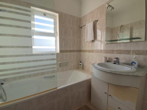 a bathroom with a sink and a bath tub and a sink at Apartamento Oásis Parque 1 in Portimão