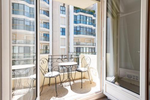 - un balcon avec une table et des chaises dans l'établissement Cannes 1-Br Apartment in the Carré d’Or, à Cannes