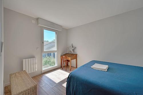 une chambre avec un lit bleu et une fenêtre dans l'établissement 333 - Parking - Clim - Terrasse, à Avignon