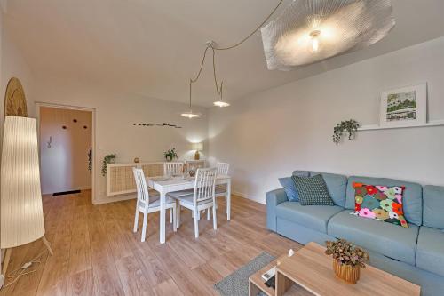 un salon avec un canapé bleu et une table dans l'établissement 333 - Parking - Clim - Terrasse, à Avignon