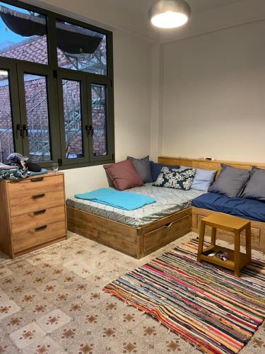 a room with a couch and a bed and windows at Loutra Edipsou Serenity Suites in Loutra Edipsou