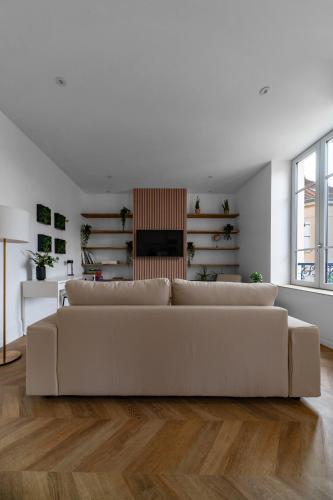 a white living room with a white couch at Résidence Jaures - Appartements design et climatisés en centre ville in Vichy