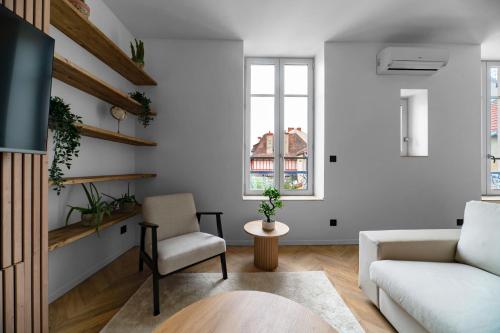 a living room with a couch and a chair at Résidence Jaures - Appartements design et climatisés en centre ville in Vichy