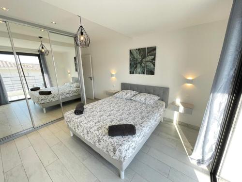 une chambre avec deux lits et un miroir dans l'établissement Villa Jérémy, à Sanary-sur-Mer