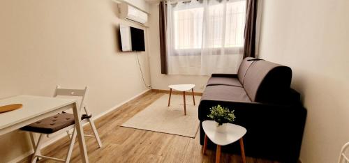 un petit salon avec un canapé et une table dans l'établissement 1 Le Saint Joseph studio with AC in the city center of Antibes, à Antibes