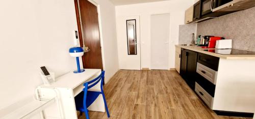 une cuisine avec un comptoir blanc et un bureau bleu dans l'établissement 1 Le Saint Joseph studio with AC in the city center of Antibes, à Antibes