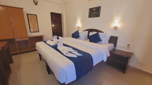 a hotel room with two beds with towels on them at tippys beach resort in Kovalam