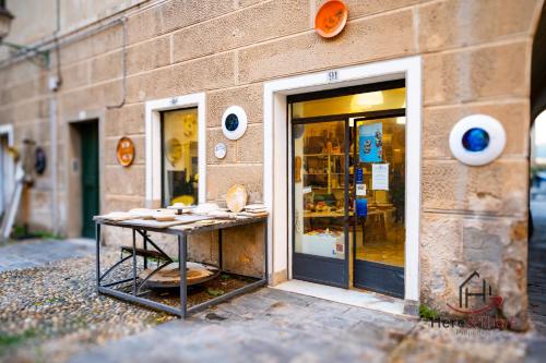 a table in front of a store front at Penthouse panoramic view - Sea 3min - AC - WiFi in Albisola Superiore