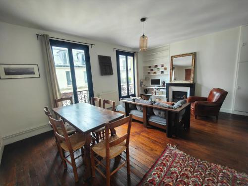 un salon avec une table, des chaises et un canapé dans l'établissement Summer price Beau 3 pièces près de Montmartre 1, à Paris