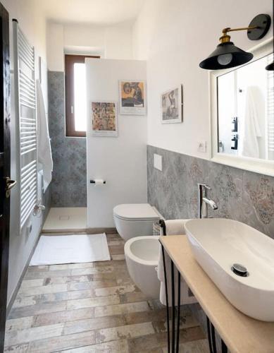 a bathroom with two sinks and a toilet and a tub at Un passo dalle torri in San Gimignano